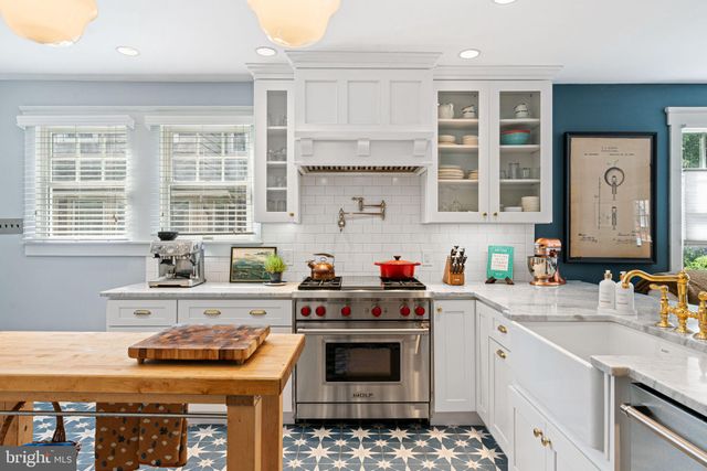 a kitchen with granite countertop a sink a stove and cabinets