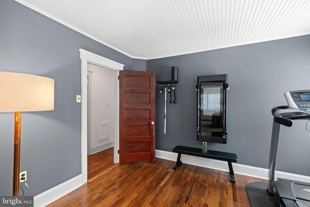 a spacious bedroom with a bed and wooden floor