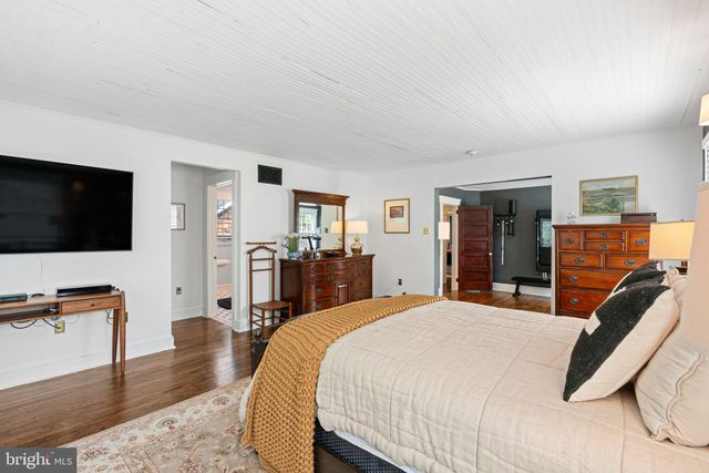 a living room with furniture floor to ceiling window and a flat screen tv
