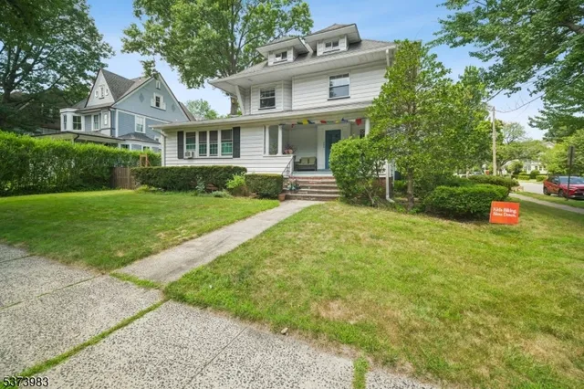 a front view of a house with a yard and trees