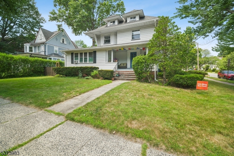 a front view of a house with a yard and trees