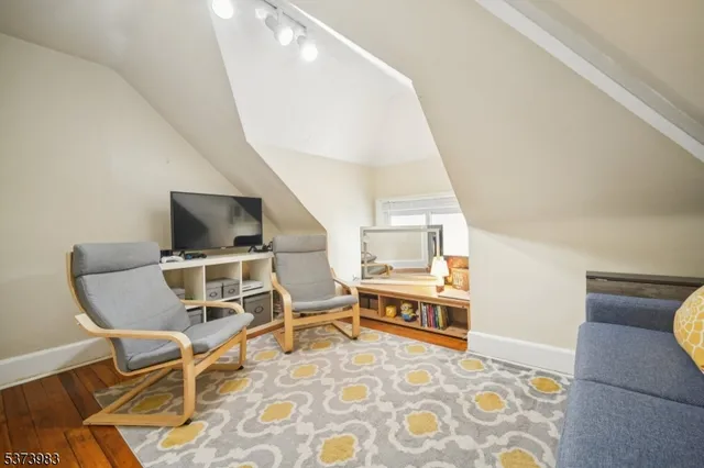 a room with a chair and white walls with wooden floor