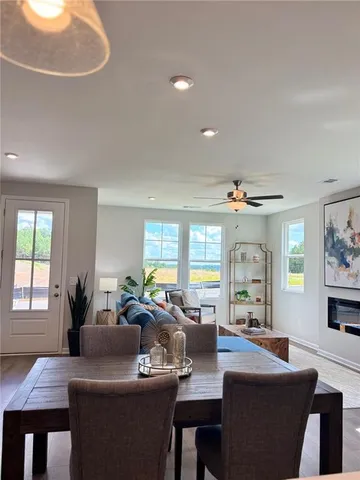 a living room with furniture a large window and a dining table