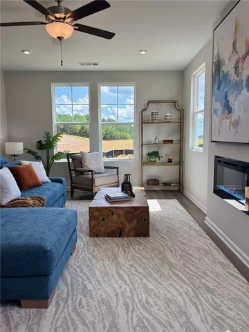 a kitchen with stainless steel appliances granite countertop a sink a stove a microwave a refrigerator a white cabinets and wooden floor