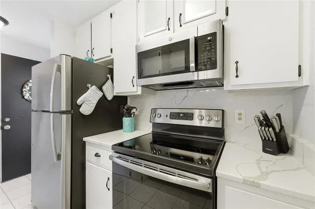a kitchen with stainless steel appliances granite countertop a refrigerator and a stove top oven
