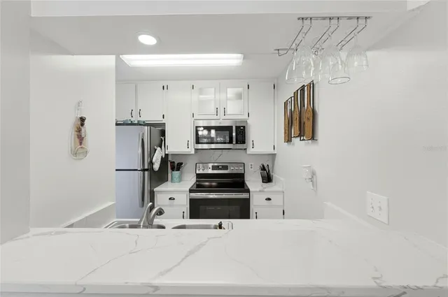a kitchen with stainless steel appliances kitchen island sink refrigerator and stove