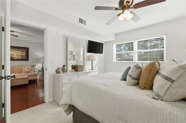 a bedroom with a large bed and a flat tv screen on a dresser