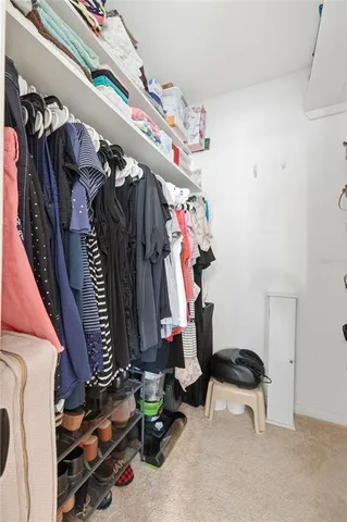 a view of walk in closet with clothes and shoes