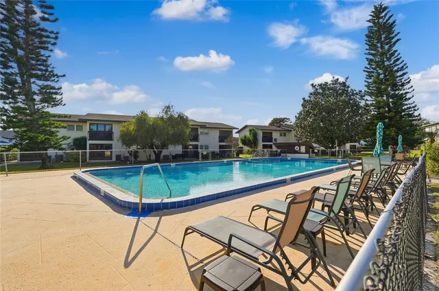 a view of a swimming pool with a patio and a yard