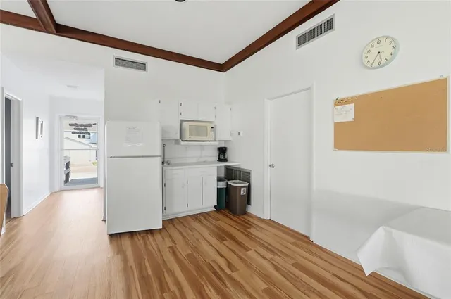 a room with white cabinets and wooden floor