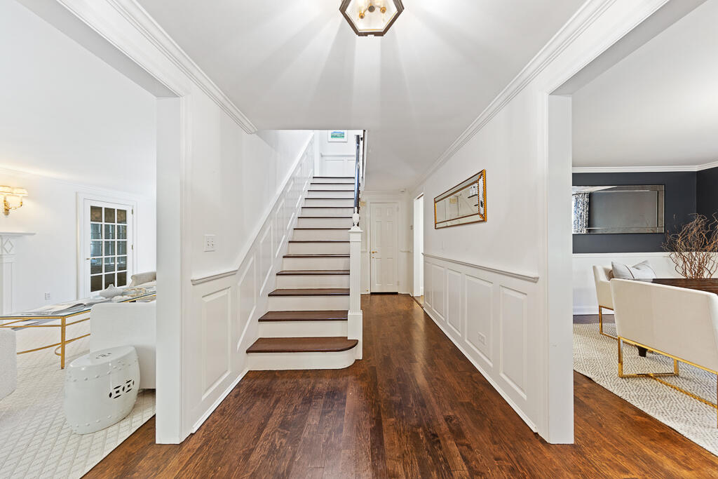 21 Halter Lane Darien, CT 06820 - Photo 11 of 45 a view of a hallway with wooden floor and staircase