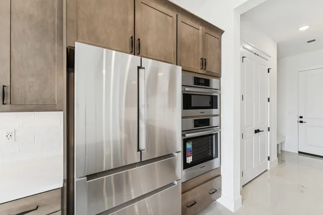 a kitchen with a sink white cabinets and stainless steel appliances