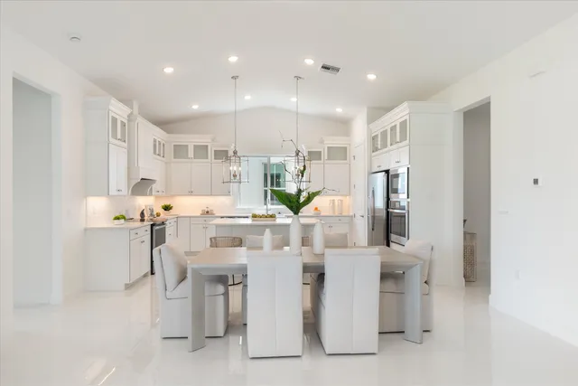 a kitchen that has a lot of cabinets in it and wooden floors