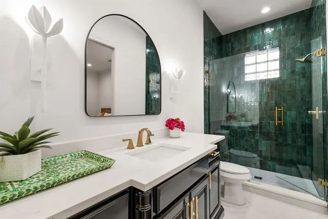 a bathroom with a sink a toilet and shower