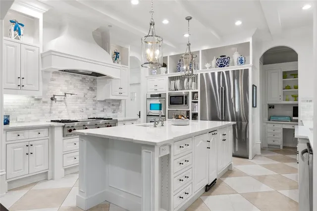 a kitchen with stainless steel appliances kitchen island granite countertop a refrigerator and a stove top oven