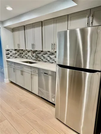 a kitchen with stainless steel appliances granite countertop a stove and a wooden floors