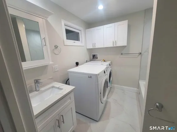 a utility room with sink dryer and washer