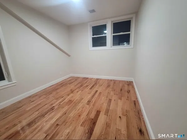a view of a big room with wooden floor and entryway