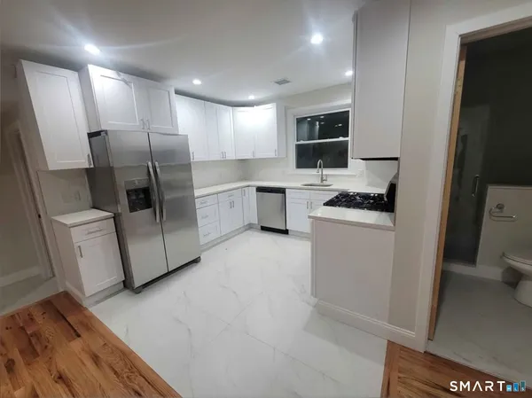 a kitchen with a refrigerator a stove top oven a sink and dishwasher
