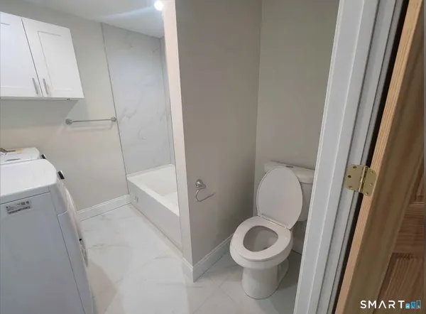 a white toilet sitting next to a sink and vanity