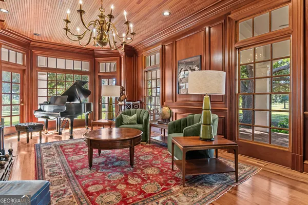 a bedroom with a bed couch and wooden floor