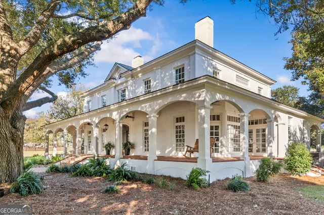 a living room with furniture a chandelier and a dining table