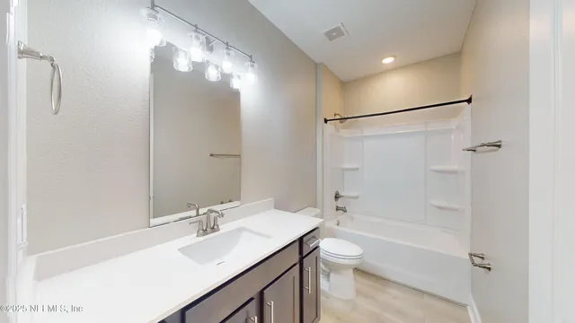 a bathroom with a bathtub shower sink vanity and a toilet