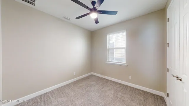 a view of a livingroom with a ceiling fan and window