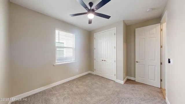 a view of a livingroom with a ceiling fan and window