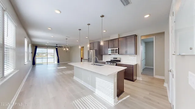 a large white kitchen with a large window a stove a sink and a counter top space