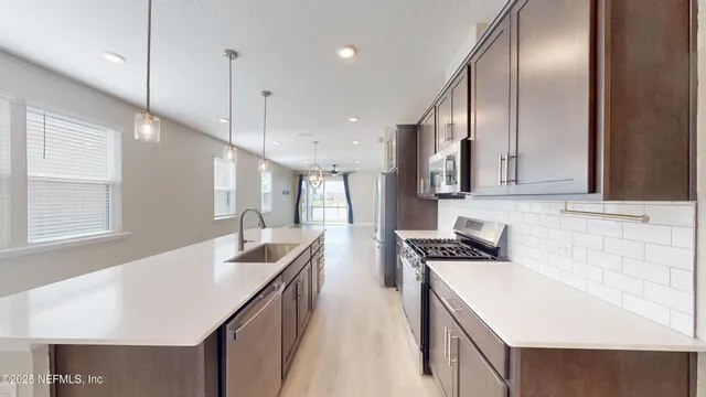 a kitchen with stainless steel appliances granite countertop sink stove and refrigerator