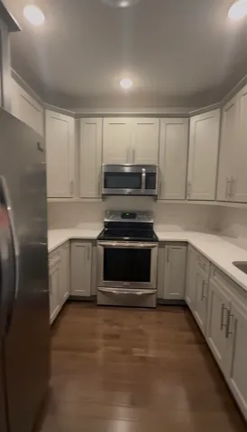 a kitchen with stainless steel appliances granite countertop a sink a stove and cabinets