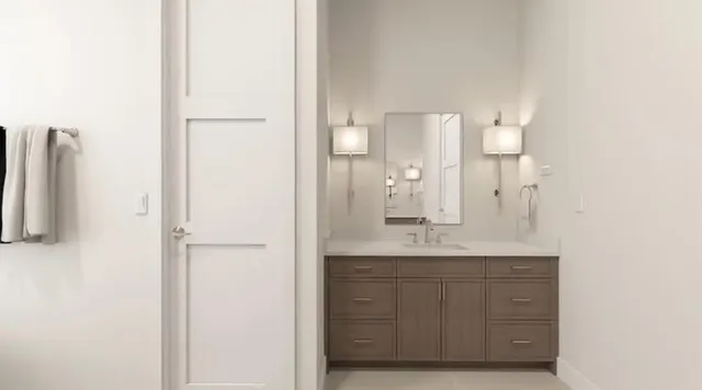 a bedroom with a bed and a lamp on dresser