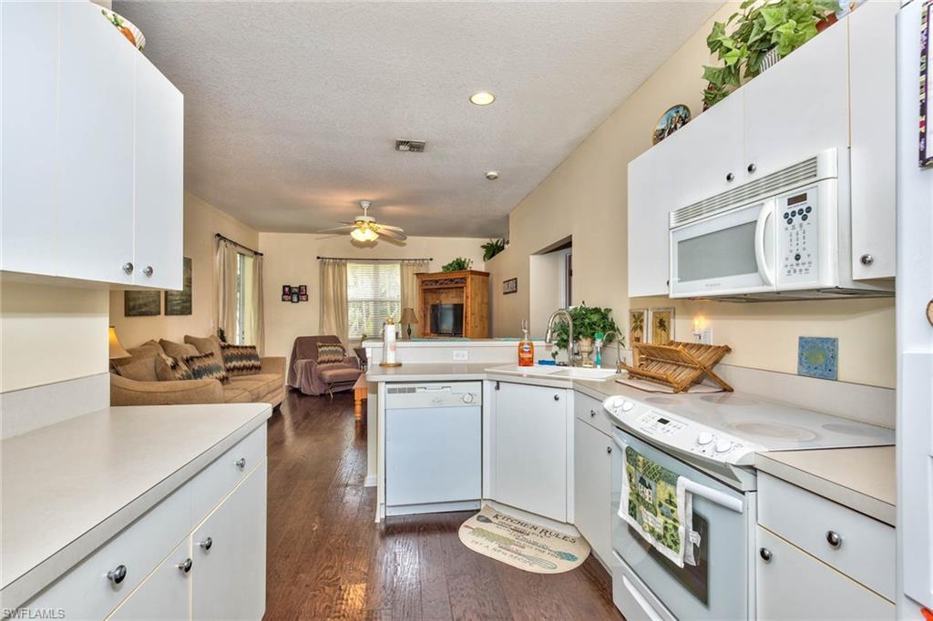 18258 Fuchsia Road Fort Myers, FL 33967 - Photo 12 of 22 a kitchen with a sink a stove cabinets and wooden floor