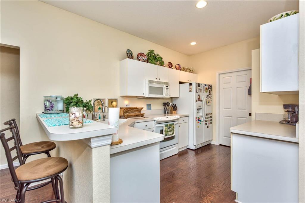 18258 Fuchsia Road Fort Myers, FL 33967 - Photo 13 of 22 a kitchen with stainless steel appliances a stove a sink a refrigerator white cabinets and chairs