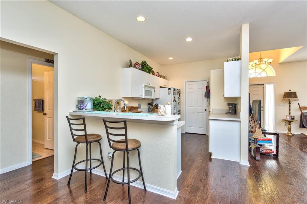 18258 Fuchsia Road Fort Myers, FL 33967 - Photo 14 of 22 a kitchen with stainless steel appliances a dining table chairs and wooden floor