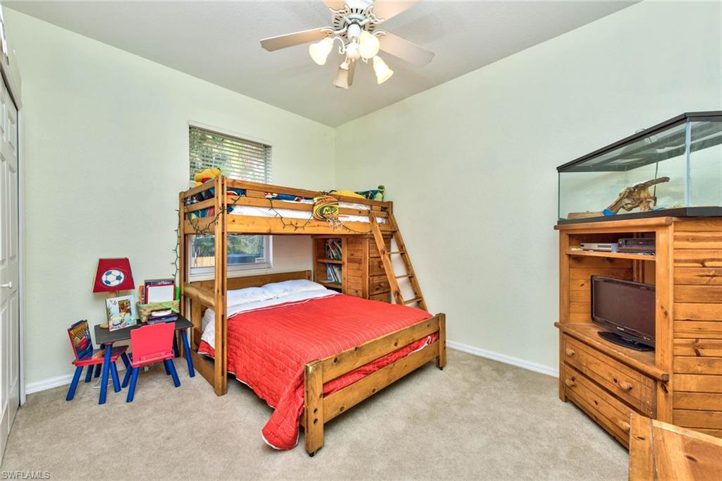 18258 Fuchsia Road Fort Myers, FL 33967 - Photo 15 of 22 a bedroom with a bed and a chandelier