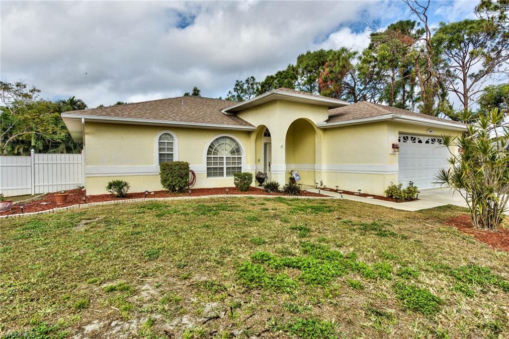 18258 Fuchsia Road Fort Myers, FL 33967 - Photo 2 of 22 a front view of a house with garden