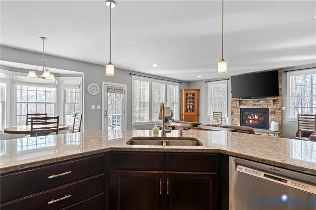 a kitchen with stainless steel appliances granite countertop sink stove refrigerator and cabinets
