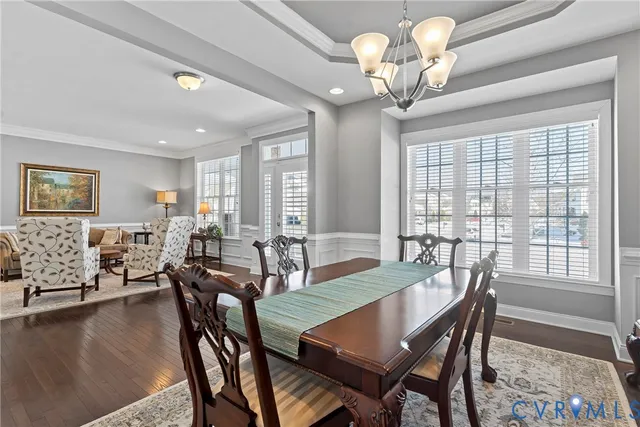 a view of a dining room with furniture a chandelier and wooden floor