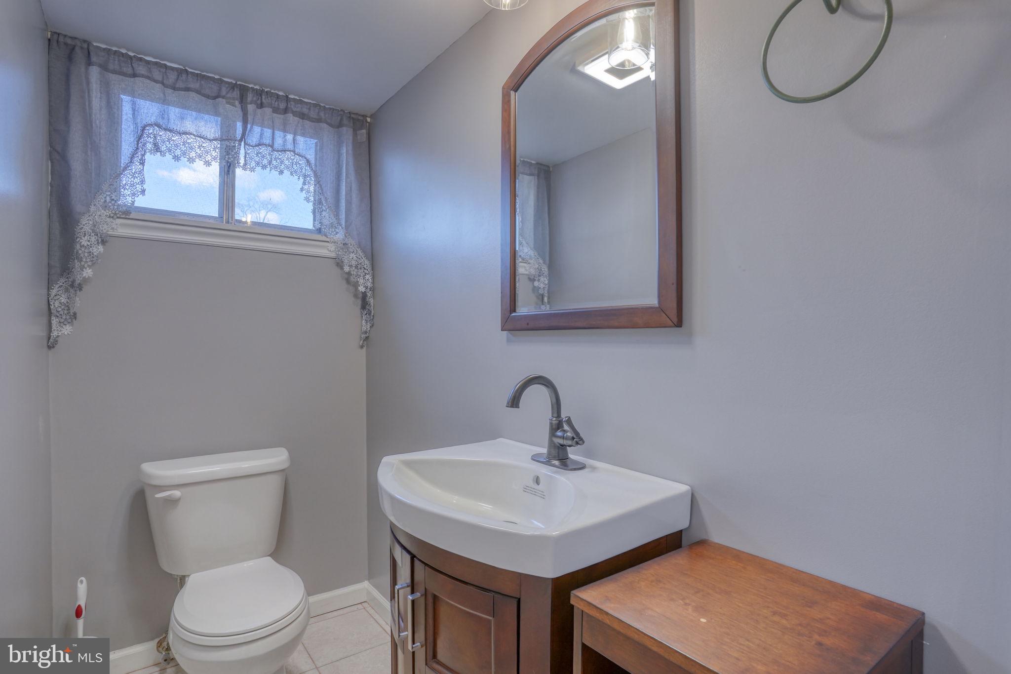 2158 South State Street Dover, DE 19901 - Photo 18 of 51 a bathroom with a toilet a sink a mirror and a window
