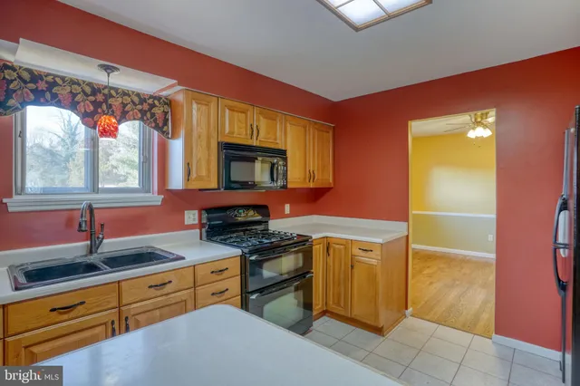 an open kitchen with a sink and a refrigerator