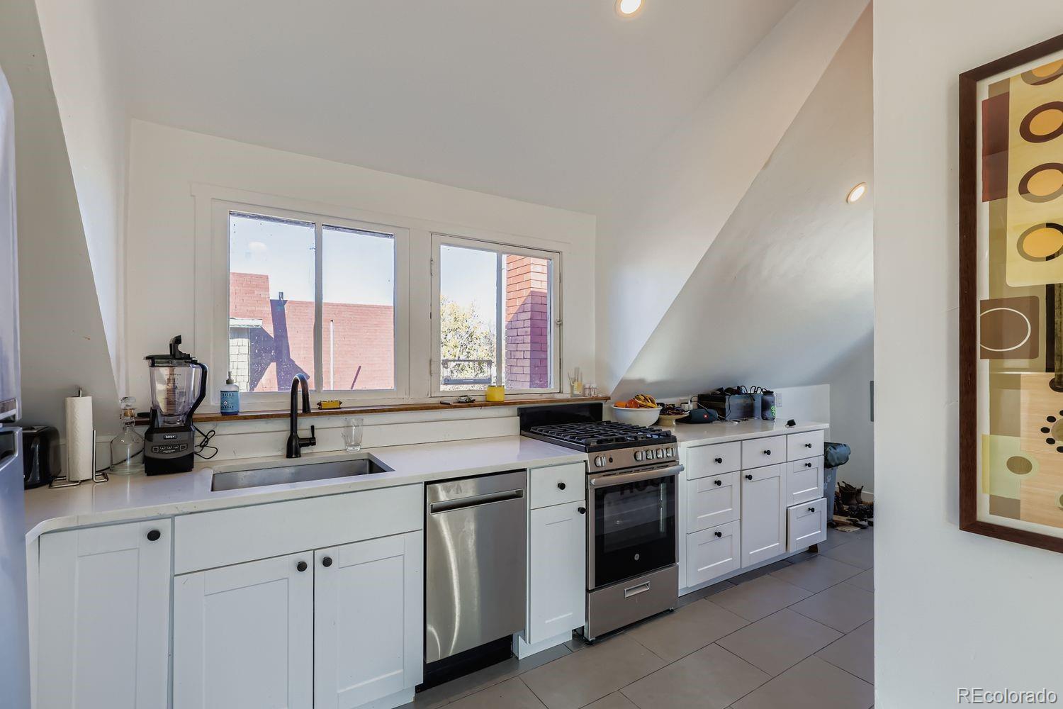 854 North Clarkson Street Denver, CO 80218 - Photo 18 of 34 a kitchen with stainless steel appliances a sink stove and window