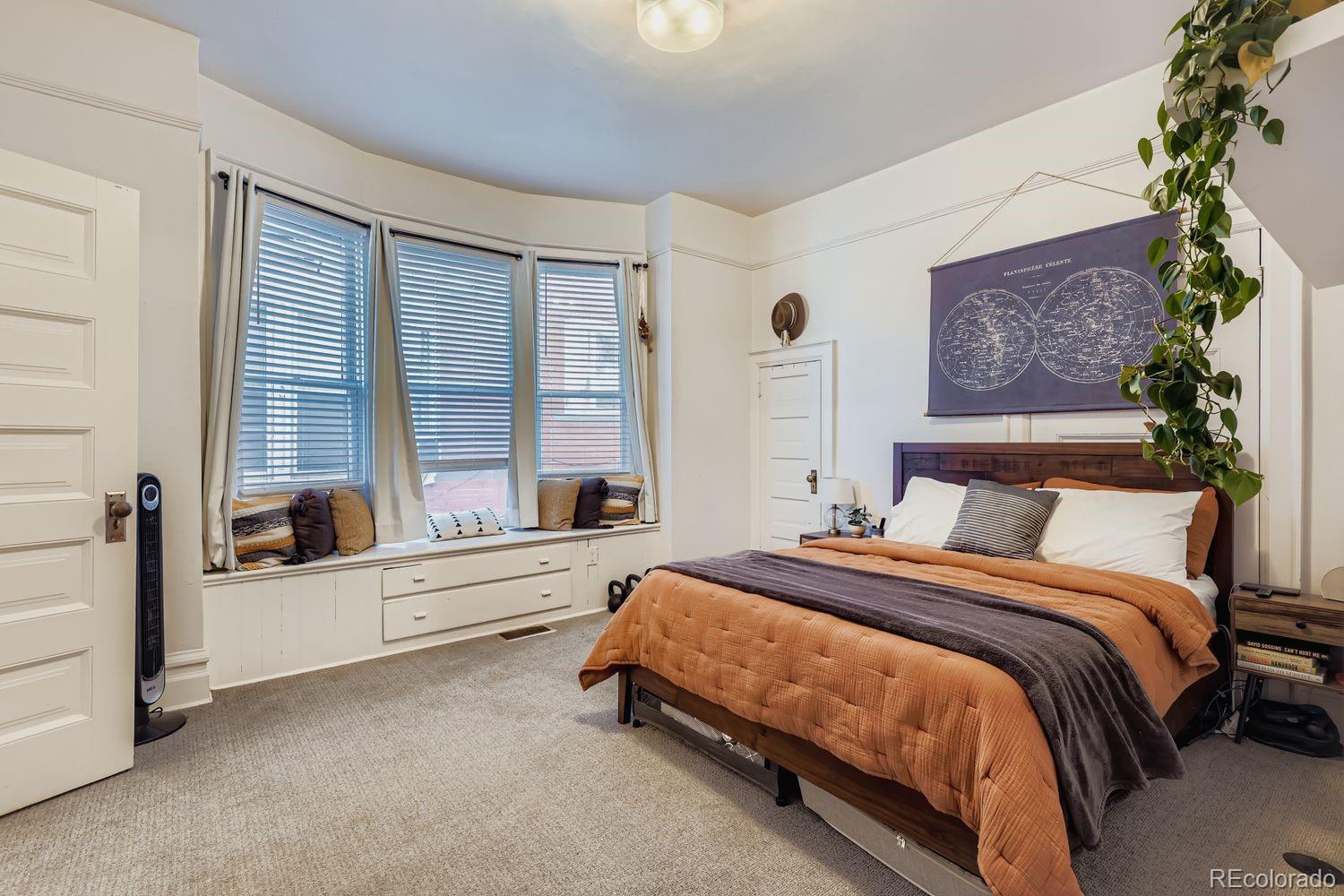 854 North Clarkson Street Denver, CO 80218 - Photo 23 of 34 a spacious bedroom with a bed and a large window