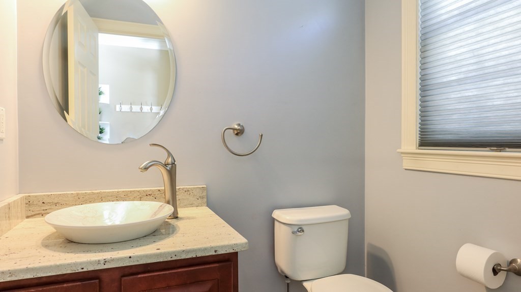 85 Dudley Road, Unit 85 Berlin, MA 01503 - Photo 14 of 39 a bathroom with a granite countertop toilet a sink and a mirror