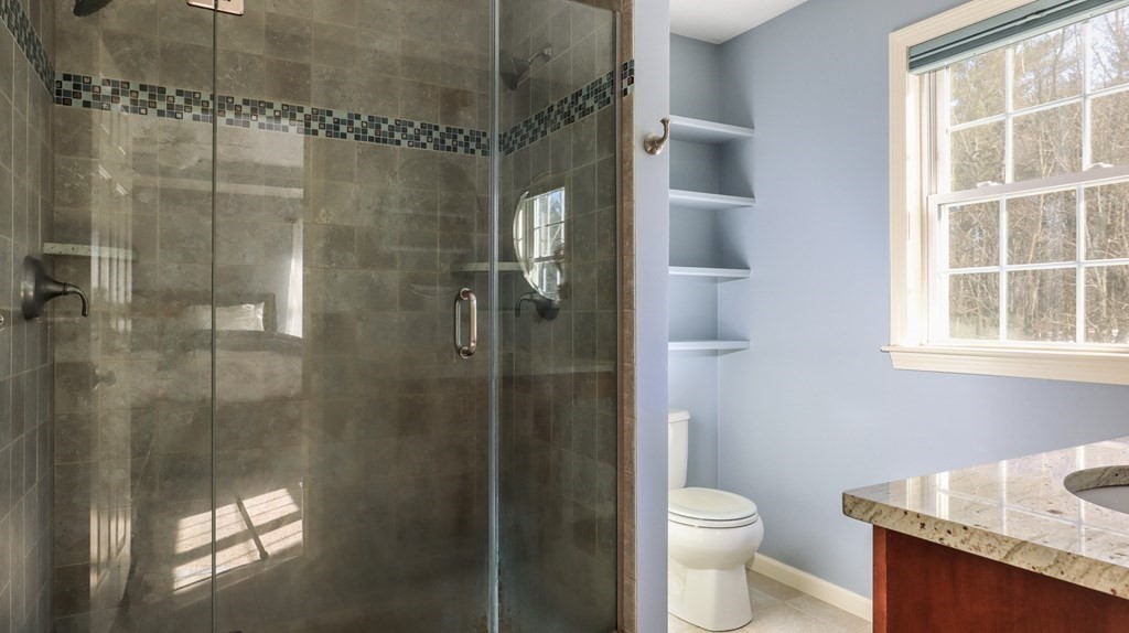 85 Dudley Road, Unit 85 Berlin, MA 01503 - Photo 19 of 39 a bathroom with a granite countertop toilet a sink and shower