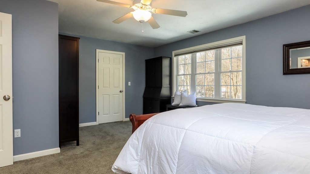 85 Dudley Road, Unit 85 Berlin, MA 01503 - Photo 23 of 39 a spacious bedroom with a large bed and a chandelier