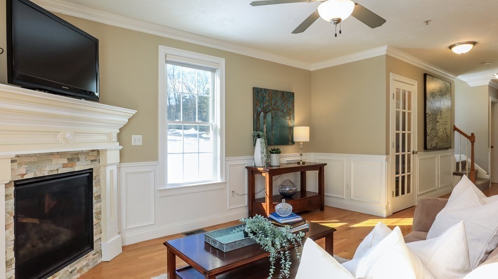 85 Dudley Road, Unit 85 Berlin, MA 01503 - Photo 8 of 39 a living room with furniture a flat screen tv and a fireplace