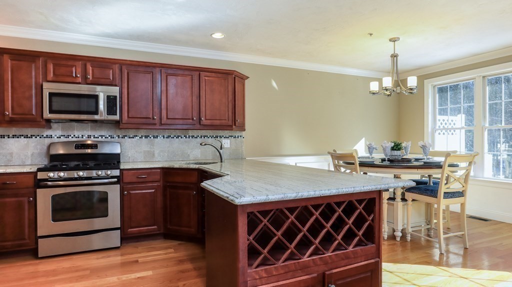 85 Dudley Road, Unit 85 Berlin, MA 01503 - Photo 9 of 39 a kitchen with a stove a sink and a microwave
