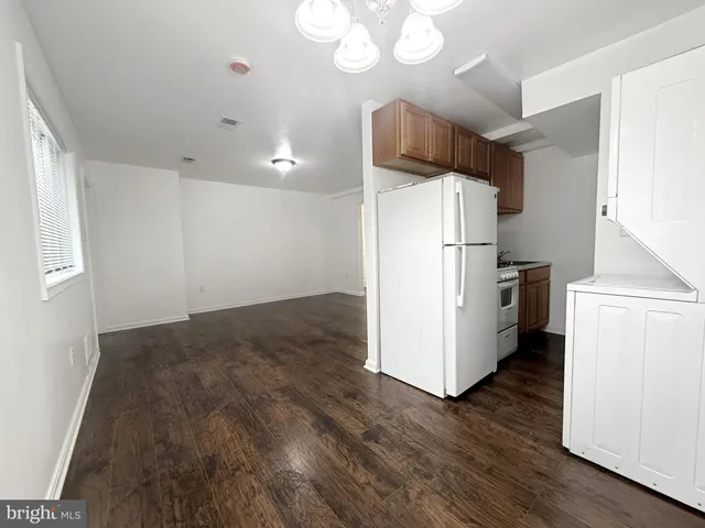 a kitchen with kitchen island wooden floors and refrigerator